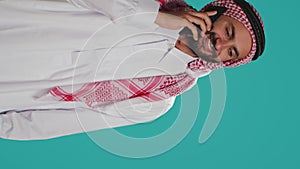 Vertical video Islamic guy in robe texting on phone