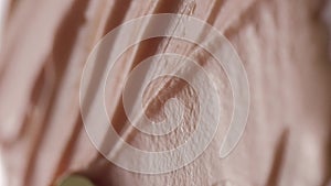 Vertical video. Macro video shooting of cosmetic cream. Beige texture. View from above