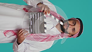 Vertical video Middle eastern filmmaker holds clapboard