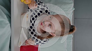 vertical video: Mother sitting with sick child patient while eating healthy food lunch in hospital ward