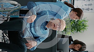 Vertical video: Portrait of senior wheelchair user sitting in waiting room area