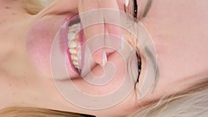 vertical video Portrait of a young woman who scratches the nose. Allergic reaction of the nose. Rhinitis, sinusitis