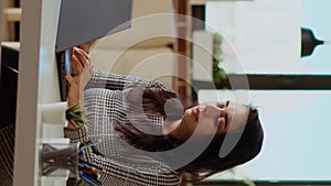 Vertical video Self employed woman sitting at computer desk, typing on laptop keyboard