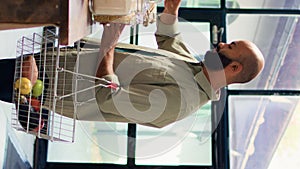 Vertical video Young client shops at supermarket