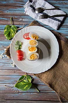 Vertical view of boiled egg slices on bacon