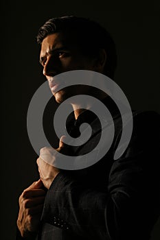Business man dressed in black suit portrait against a dark background. Closeup portrait handsome man,
