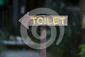 A vertical view of classic simple design handmade wooden sign of toilet give direction to WC , Thailand