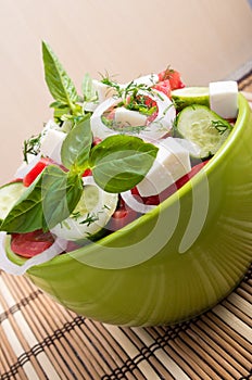 Vertical view close-up on a green bowl with a salad