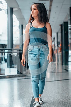 Vertical view of a cute young girl walking in a modern building while staring off into the distance