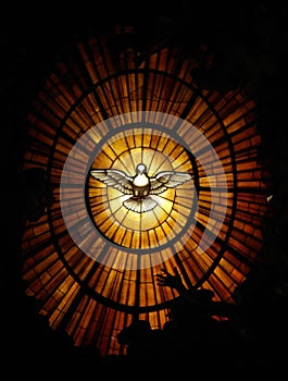 Vertical view of the dove of the Holy Spirit on the stained glass in St. Peter's Basilica