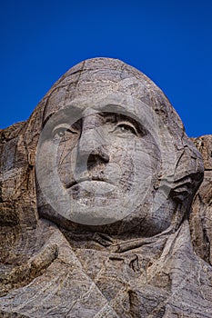 Vertical view of George Washington's portrait under the blue sky in Mount Rushmore landmark