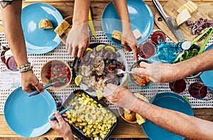 Vertical view of group of friends or family eating together. Friendship and celebration at linch time with food. People enjoying