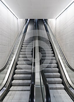Vertical view of a long an empty escalator in a train station