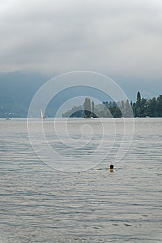 Vertical view of a man swimming in the tranquil Lake Lucern