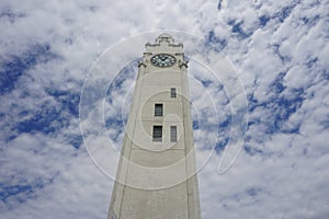 A vertical view of Montreal Clock Tower in Old Port. Background is a blue cloudy sky