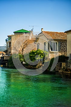 Vertical view of old stone houses in Medieval village L`Isle-sur-Sorgue, Vaucluse, Provence, France. Famous Sorgue river with