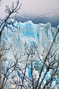 Vertical view of Perito Moreno Glacier, in El Calafate, Argentina, against a grey and cloudy sky.