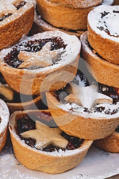 Vertical view of a pile of delicious Christmas mince pies with sugar powderon top