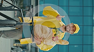 Vertical View. Portrait of Handsome Delivery Person in Yellow Uniform with bike.