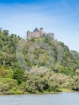 Vertical view of Scönburg castle on the Rhine river, with the river in the foreground