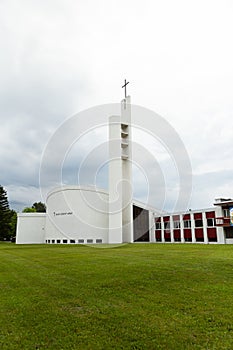 Vertical view of striking 1967 modern style white concrete Saint-Benoit-Abbé church
