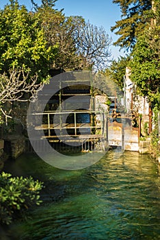 Vertical view of wheel of a water mill in Medieval village L`Isle-sur-Sorgue, Vaucluse, Provence, France. Famous Sorgue river wit