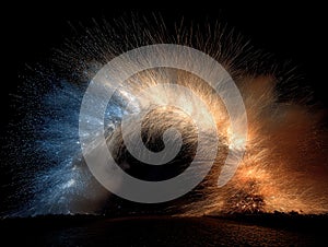 Vertical white fire pillar and blue-yellow dual firework arc exploding side-by-side in a dark starry sky, with water reflection