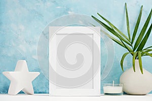 Vertical white Photo frame mock up with plants in vase, ceramic decor on shelf. Scandinavian style