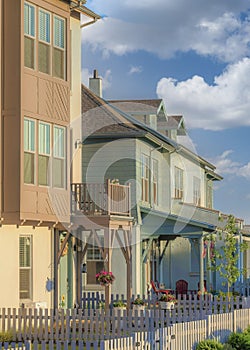 Vertical White puffy clouds Residential buildings exterior with white picket fence and gate