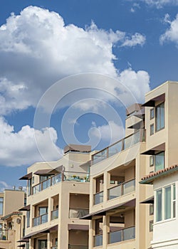 Vertical White puffy clouds Residential buildings with glass railings at La Jolla, Californi
