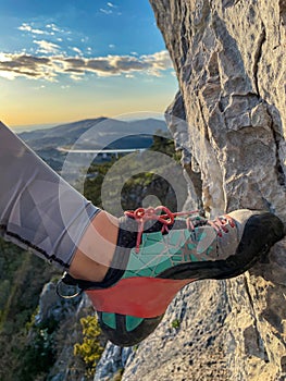 VERTICAL: Woman's climbing shoe gains traction as she steps on a rocky foothold.