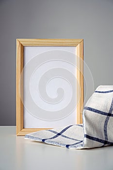 Vertical wooden frame, checkered kitchen towel on gray background. Culinary, menu, recipe concept.