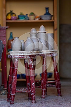 Vertical of a workshop with ceramic jars on an antique stool