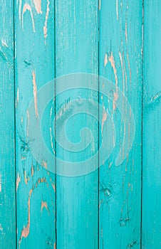 Vertically located colored distressed turquoise paint boards, old fence