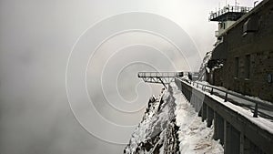 Vertiginous view of the pontoon of the sky at the peak of the Midi of the Pyrenees under the snow
