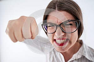 Very angry businesswoman punching towards the camera