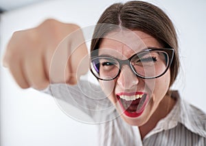 Very angry businesswoman punching towards the camera