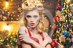 Very beautiful blonde girl over Christmas tree - close up portrait. Retro woman with retro curly hair near the Christmas