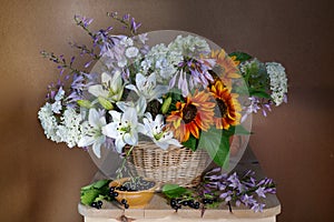 Very beautiful bouquet of garden flowers in a basket.Still life with flowers