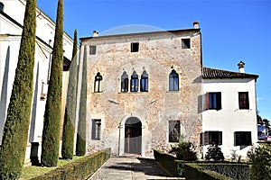 Very beautiful facade of the villa, which is located to the right of the church, between the green of the cypresses and the blue s