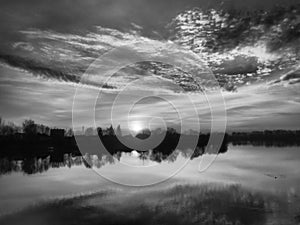 Very beautiful sunset over the water. River bank and horizon. Setting sun. A black and white photograph with increased