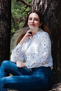 Very beautiful young woman in coniferous forest in summer in hot sunny weather