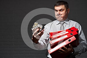 Very busy businessman closeup portrait, posing with red folders, overworking concept, dark wall background