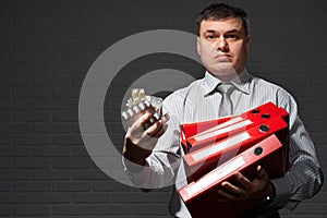 Very busy businessman closeup portrait, posing with red folders, overworking concept, dark wall background