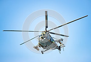 Very close frontal view of an attack helicopter against the sky, with missiles, rockets and machine gun. Military