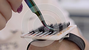 Very close-up of beautiful devices and parts in the beauty salon. Stylist shows a set of false eyelashes.