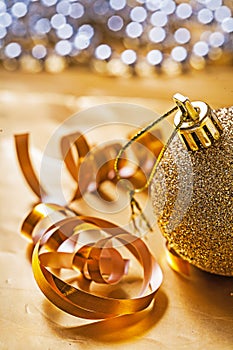 Very close up view on gold colored christmas bauble on table wit