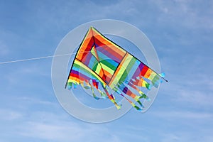 very colorful kite flying on the blue sky