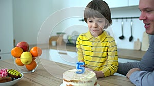 Very cute boy celebrating his birthday with a cake & happy father. Happy birthday of 5 years. Father`s Day. Little boy