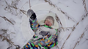 A very cute happy little boy in the Park in winter. Winter time. Happy boy having fun in a snow winter park. He is happy